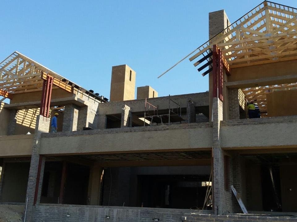 Double-storey structure with roof trusses going up over cast concrete