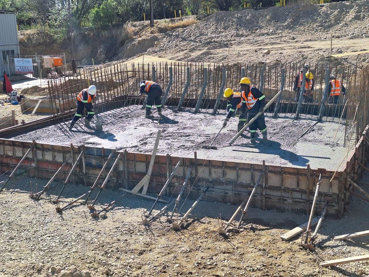 AIW crew placing and screeding concrete on a reinforced slab