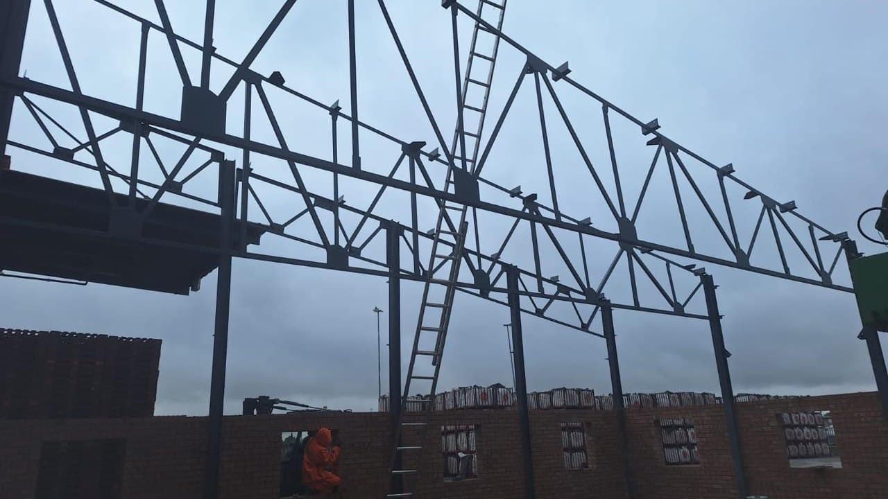Roof trusses being erected over a new brick industrial building on an AIW Construction site